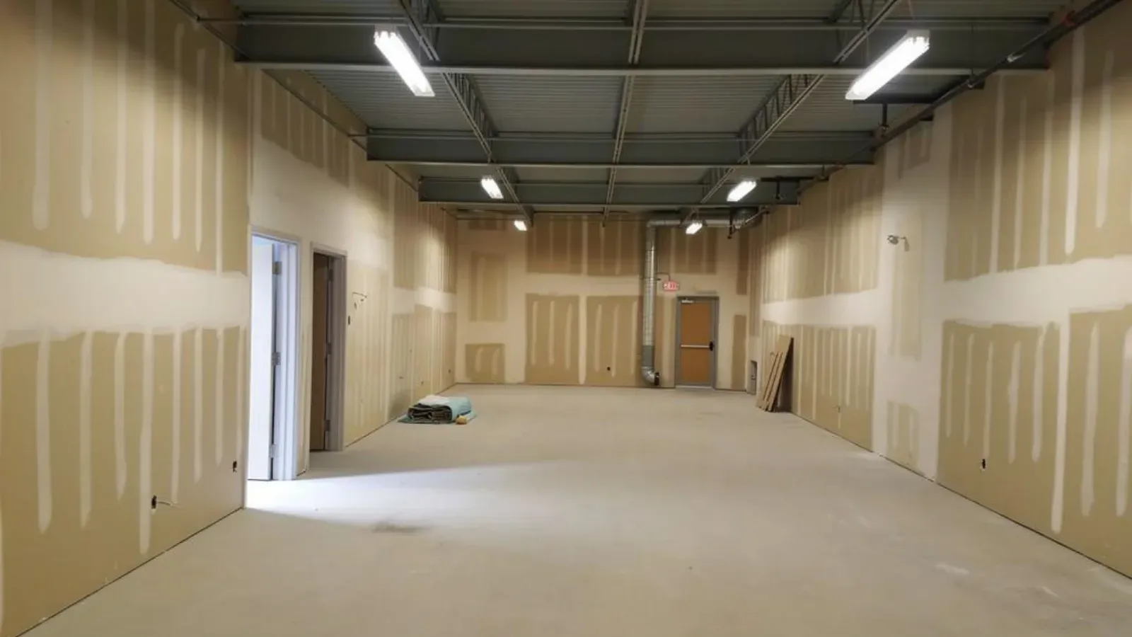 Fire-rated drywall demising walls taped from floor to deck in a commercial interior